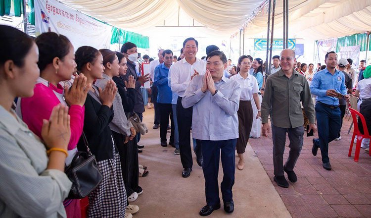 Heng Sour and Pursat officials meet with former migrant workers during employment announcement event.