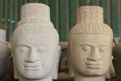 Cambodian artisan carving stone sculpture using traditional techniques