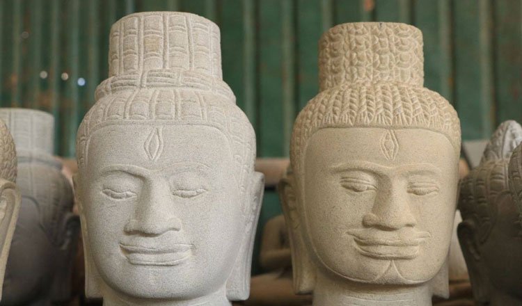 Cambodian artisan carving stone sculpture using traditional techniques