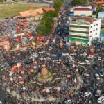 Crowds of tourists enjoying Khmer New Year celebrations in Kampot with riverfront views and festive activities
