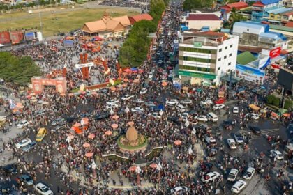 Crowds of tourists enjoying Khmer New Year celebrations in Kampot with riverfront views and festive activities