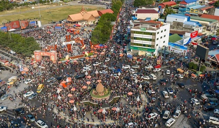 Crowds of tourists enjoying Khmer New Year celebrations in Kampot with riverfront views and festive activities